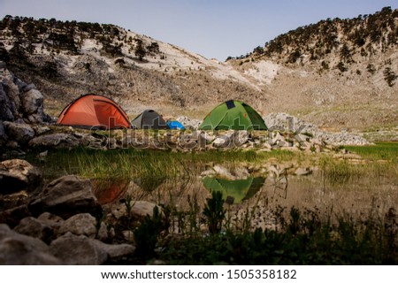 Tent standing on the extreme parking before climbing to Tahtali mountain in Turkey on the background of rocks and trees near the pond
