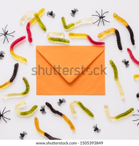 Envelope with worm candies and spiders around
