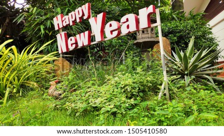 Happy New Year sign red and white color in grass green  garden 