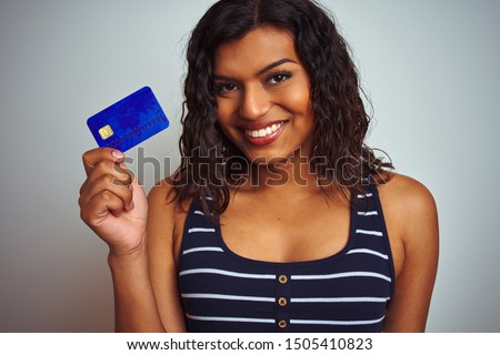 Transsexual transgender customer woman holding credit card over isolated white background with a happy face standing and smiling with a confident smile showing teeth