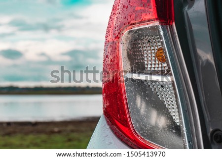 The taillight of the car that is wet with falling rain 