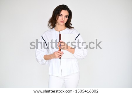 Concept photo portrait of a cute pretty beautiful brunette girl with excellent makeup in white clothes with a folder in her hands on a white background. In different poses with emotions.