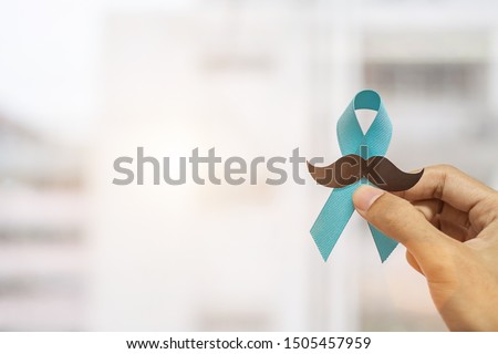 November Prostate Cancer Awareness month, Man holding Blue Ribbon with mustache  for supporting people living and illness. Healthcare, International men, Father and World cancer day concept Royalty-Free Stock Photo #1505457959