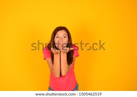 woman blows a kiss on color background