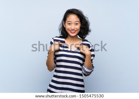 Asian young woman over isolated blue background with surprise facial expression