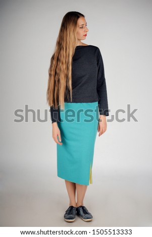 isolated photo: beautiful model with long hair shows off clothes. the concept of modeling business, is casual clothes