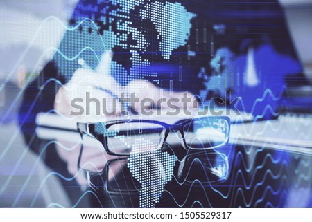 Forex chart hologram on hand taking notes background. Concept of analysis. Double exposure
