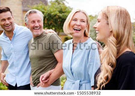 Family With Senior Parents And Adult Offspring Walking And Talking In Garden Together Royalty-Free Stock Photo #1505538932