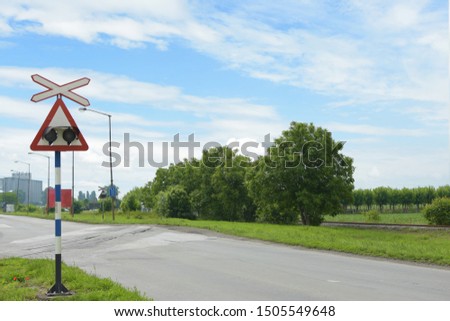 Saint Andrews Cross or cross buck with lights it is a sign for level crossing intersection where a railway line crosses a road or path on a nice sunny day