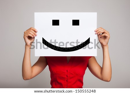 Woman holding a smiling face emoticon Royalty-Free Stock Photo #150555248