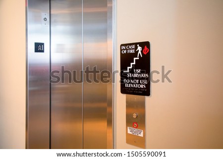 Do not use elevator in case of fire sign beside the elevator. safety concept.