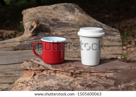 red metal coffee cup and white glass coffee cup on wood 