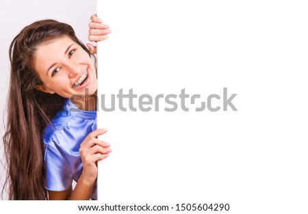 Attractive girl with braces presenting empty board