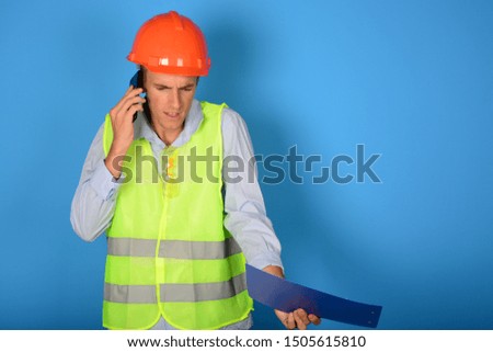 builder with helmet holds tablet folder and phone in his hands on an isolated background