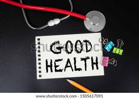Good Health. Red stethoscope, stationery and notebook on black table