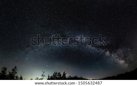 Panorama of night sky above lake Madh in National Park Lure, Albania