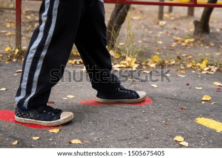 The boy follows the tracks on the pavement. Traces of paint on t