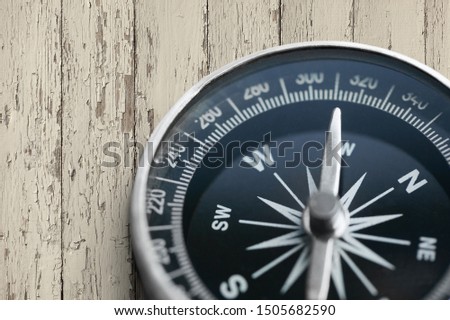 Compass close up lying on a wooden table top view
