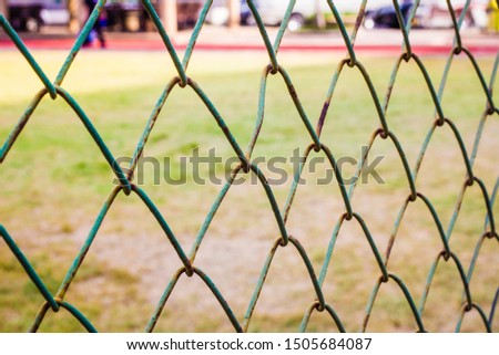 Closeup of green fence grid on school football field