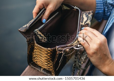 Stylish woman with snakeskin handbag outdoors.