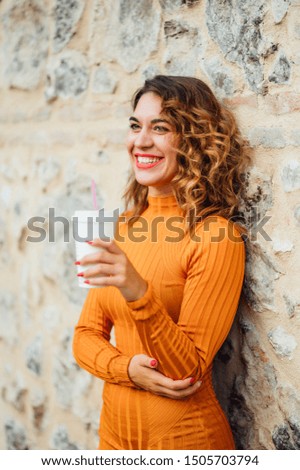 Pretty woman drinking coffee while walking in the streets of Madrid Spain