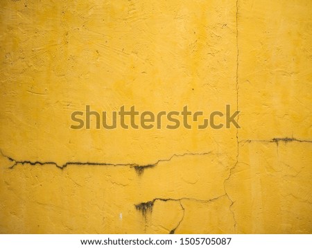 The old yellow wall with cracks used as a background