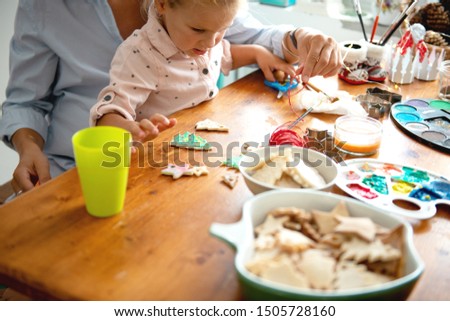 Mother and daughter painting Christmass ornaments