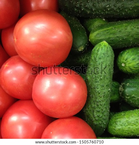 Macro photo of a vegetable red tomato and green cucumbers. Fruit vegetables tomatoes and cucumbers. Background of pink tomatoes with green cucumbers Royalty-Free Stock Photo #1505760710