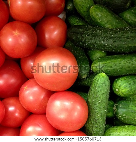 Macro photo of a vegetable red tomato and green cucumbers. Fruit vegetables tomatoes and cucumbers. Background of pink tomatoes with green cucumbers Royalty-Free Stock Photo #1505760713