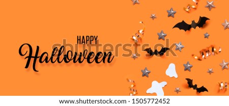 Autumn holiday composition. Halloween holiday concept with bats, ghost, spider web, stars over a orange background.