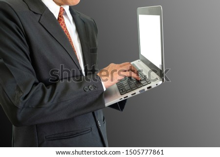 Businessman is typing on keyboard computer laptop on gray background with clipping path.