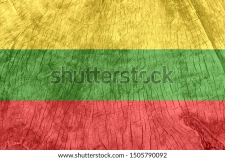 Lithuania flag on an old wooden surface. Textured wallpaper background for design.