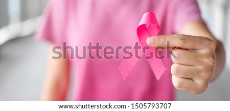 October Breast Cancer Awareness month, Woman in pink T- shirt with hand holding Pink Ribbon for supporting people living and illness. Healthcare, International Women day and World cancer day concept Royalty-Free Stock Photo #1505793707