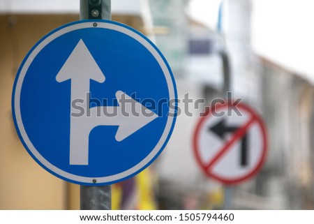 Road sign double arrow forward and to turn right. Street sign in the city, for motorists. In the background another road sign with a ban on turning left.