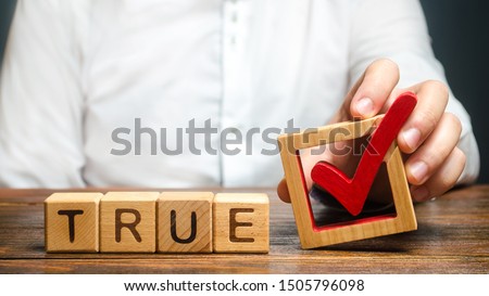 A man holds a red check mark over word True. Confirm the veracity and truth. Fight against fake news hostile propaganda. Confirmation facts, refutation of rumors. Debunking Myths and Misconceptions Royalty-Free Stock Photo #1505796098