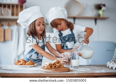 Cookies is ready. Family kids in white chef uniform preparing food on the kitchen. Royalty-Free Stock Photo #1505805005