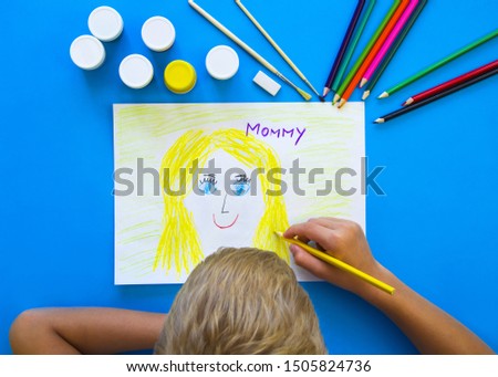 A child draws a portrait of his mother to give on mother's day.Happy family concept. Mother's day.Flat position, top view-image