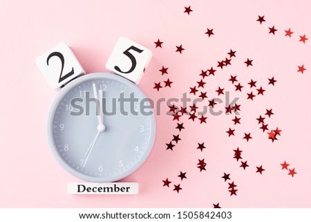 Christmas background with alarm clock and festive stars cofetti on pastel pink background, top view. Flat lay minimalism style decorations