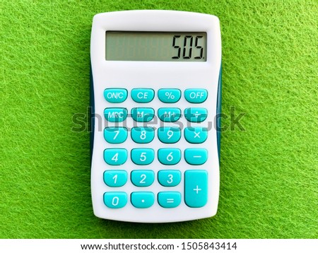 Top view of a calculator on green background