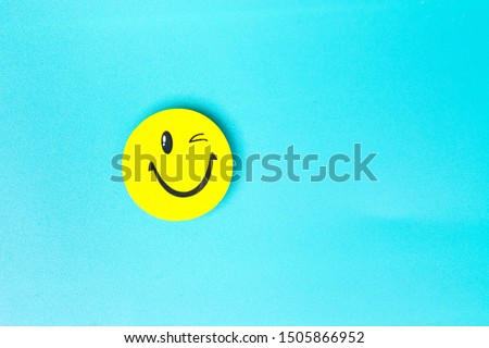 Positive Funny smiley face on a turquoise cardboard background. Copy space for advertising and texts