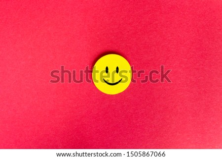 Positive Funny smiley face on a red cardboard background. Copy space for advertising and texts