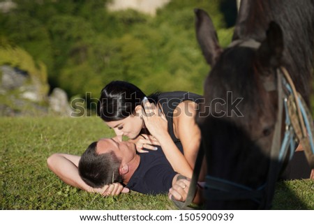 Beautiful couple with a horse in the mountains