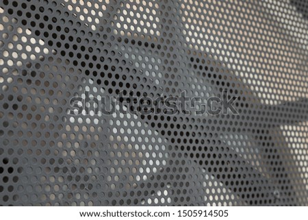 Diagonal view of gray perforated metal panel at building facade
