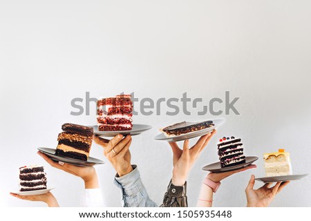 Concept for cafe or bakery with desserts: plates with different cakes in people's hands, place for your text Royalty-Free Stock Photo #1505935448