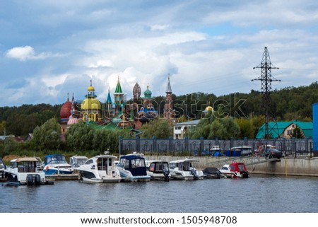 View onto Temple of All Religions & boat pierce from river Volga side, Kazan, Russia. Temple is unique by uniting signs of all world religions. Writing on building translates as 'Universal Temple'