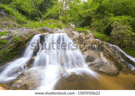 River waterfall slow motion at jungle forest with beautiful fairy-tale effect. Tropical waterfall with a lot of white water flows. Mountain in northern Thailand