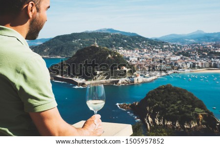 Drink glass white wine in male hands holidays looks top view city coast yacht from observation deck, romantic lonely tourist man toast with alcohol panoramic cityscape downtown, relax person tourism 