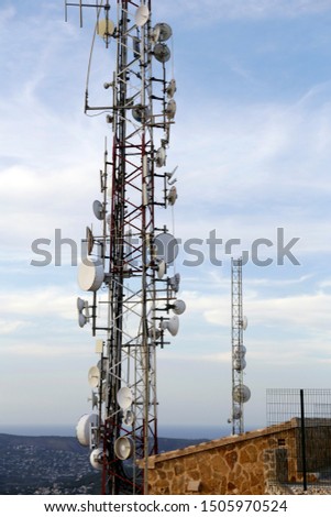 Telecommunications tower, antenna and satellite dish with blue sky. Communication theme. Wireless technology. 