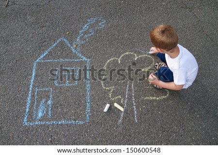 Boy drawing house and tree with chalk