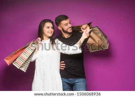 Family bought excellent clothes. Couple with luxury bags violet background.